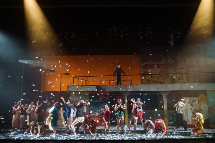 Prop paper money raining down on the stage as the chorus and singers snatch them out of the air